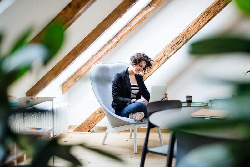 Wycena - Pani siedząca na fotelu z laptopem na kolanach